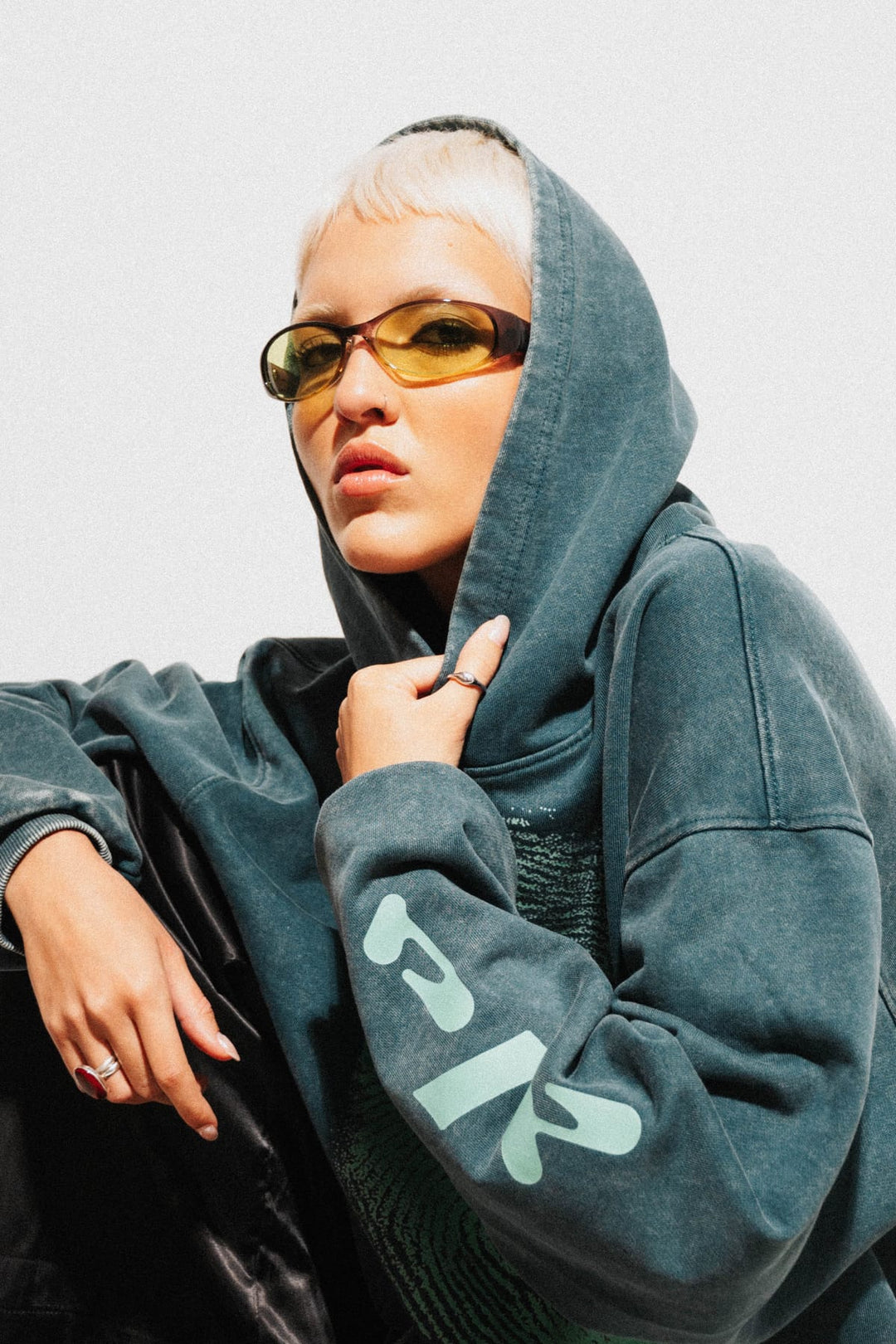Close-up portrait of model in DNA Fingerprint hoodie with yellow-tinted sunglasses in Miami daylight
