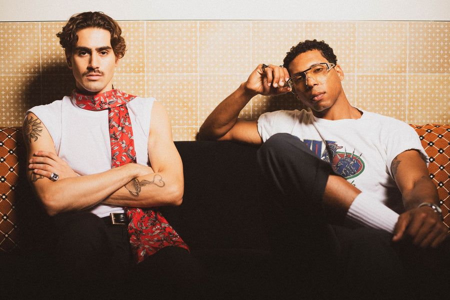 Two friends on a tiled banquette, one in a red floral scarf