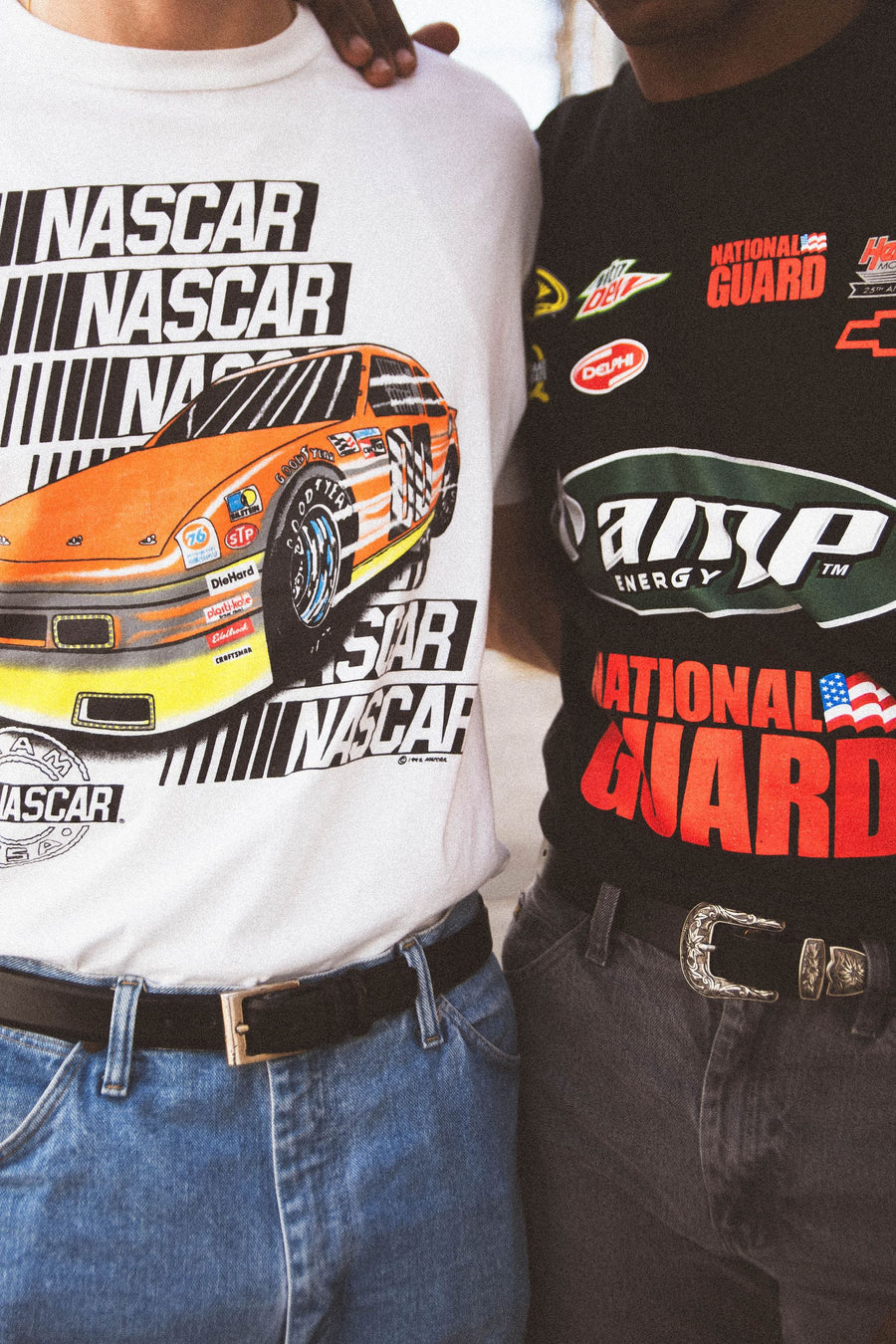 Close-up of a NASCAR tee and a National Guard racing tee with western buckles